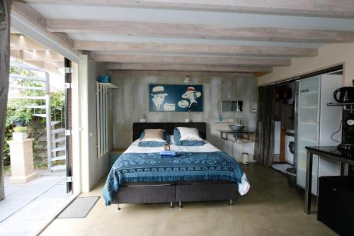 a bedroom with a bed with a blue comforter at Vakantie Studio Grou in Grou