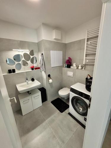 a bathroom with a sink and a washing machine at Stylish Chill Garden Apartment in Bratislava