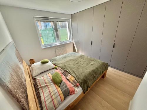a small bedroom with a bed and a window at Stylish Chill Garden Apartment in Bratislava
