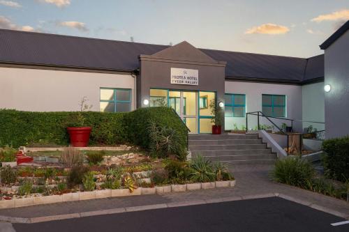 a building with a garden in front of it at Protea Hotel by Marriott Cape Town Tyger Valley in Bellville