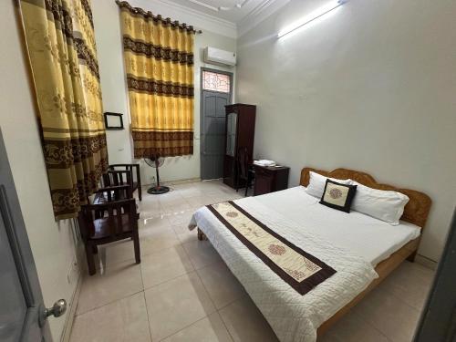 a bedroom with a bed and a chair in it at Khách sạn Thuỷ Chi in Bắc Quang