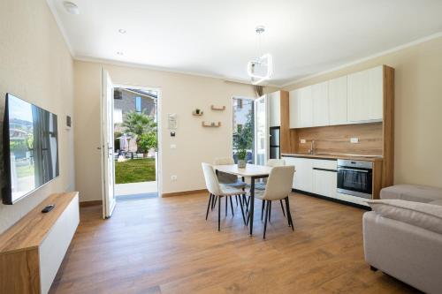 a kitchen and living room with a table and chairs at Villa Hoxha 80 in Durrës