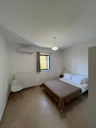 a bedroom with a large bed and a window at Athanasia's Eremion in Zagora