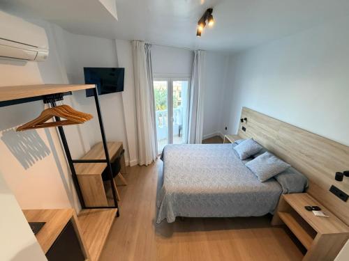 a small bedroom with a bed and a television at Hostal Juan Carlos in Carboneras