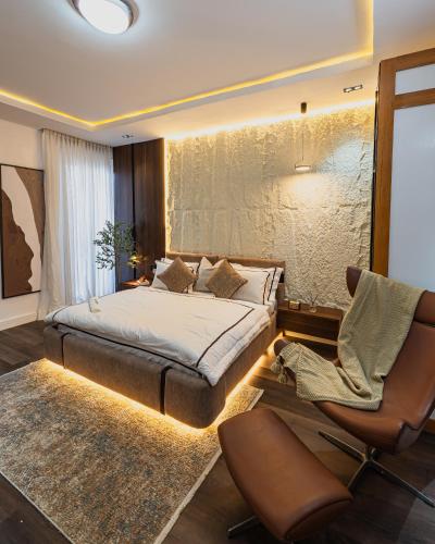 a bedroom with a bed and a couch and a chair at M&N Apartment in Ikate