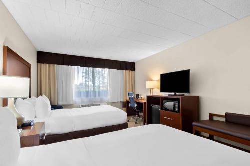 a hotel room with two beds and a flat screen tv at Comfort Inn Somerset in Somerset