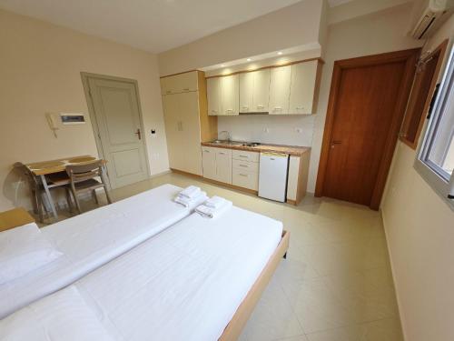 een slaapkamer met een groot wit bed in een kamer bij Thoma's K Studios in Vlorë