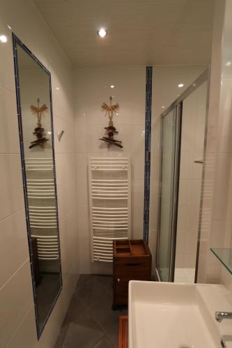 une salle de bain avec un miroir et un lavabo dans l'établissement Le Panoramique, à La Baule