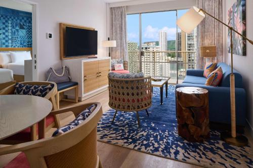 a hotel room with a living area with a large window at OUTRIGGER Waikiki Paradise Hotel in Honolulu