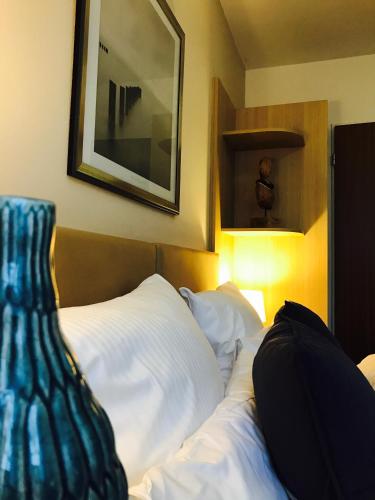 a bed with a blue vase sitting on top of it at ONNO Boutique Hotel & Apartments in Rendsburg