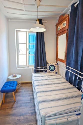 a bedroom with a bed and a blue curtain at Plomari Nest in Plomari