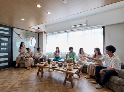 a group of people sitting in a living room at LIVE HEART House in Nara