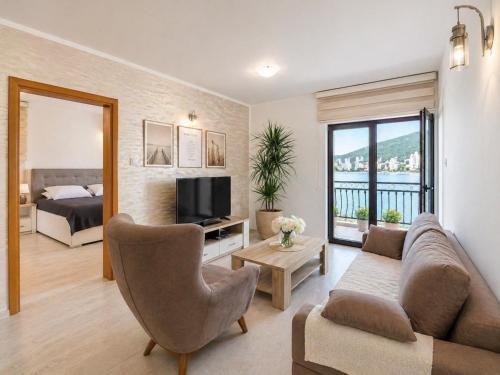 a living room with a couch and a television and a bed at Old Sailor`s house Rafailovici in Rafailovici