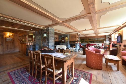 uma grande sala de estar com mesa e cadeiras em Hotel La Rouja em Champoluc