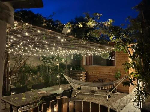a patio with a hammock and lights at night at La Casetta in Gattières