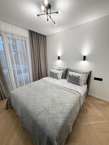 a bedroom with a bed and a ceiling fan at Pajūrio Namai in Palanga