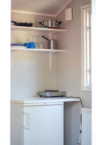 a kitchen with white shelves and a white refrigerator at Stockholm Ängby Camping in Stockholm