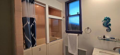 a bathroom with a shower and a sink and a window at Distinguished Home in Scranton