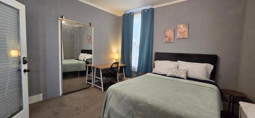 a bedroom with a bed and a desk and a mirror at Distinguished Home in Scranton