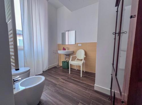 a bathroom with a sink and a toilet and a chair at Casa di in Ascoli Piceno