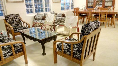 a room with chairs and a table and a dining room at Colonels inn in Ooty