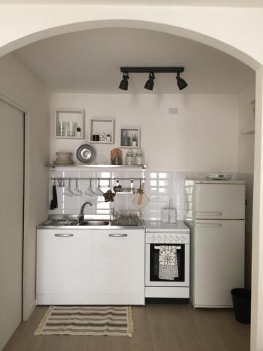 Cosy Home Napoli في نابولي: مطبخ مع موقد أبيض ومغسلة