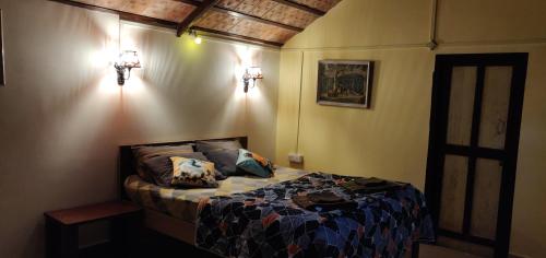 a bedroom with a bed and two lights on the wall at Enchanting woods Yercaud in Yercaud