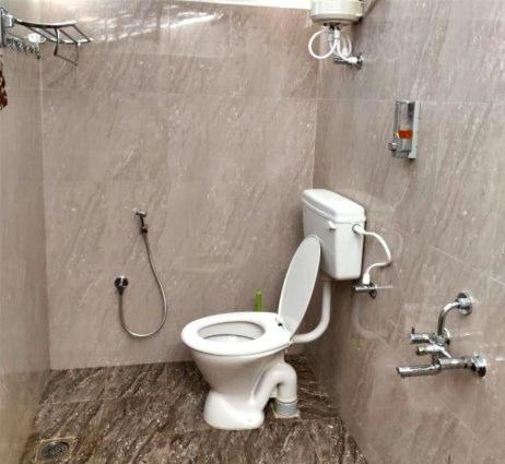 a bathroom with a white toilet in a stall at Enchanting woods Yercaud in Yercaud