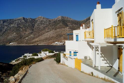 a road between white buildings with a view of the ocean at Kamara in Kamarai