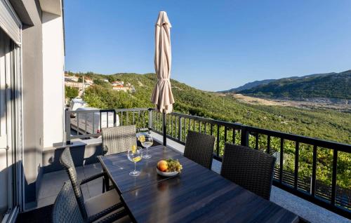 a table with a bowl of fruit on a balcony at Beautiful Home In Vrgorac in Vrgorac