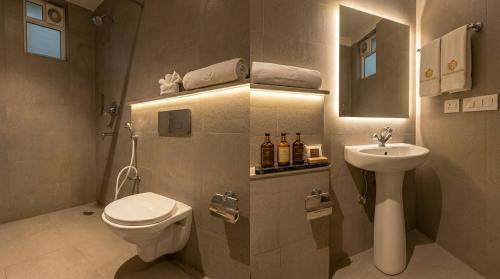 a bathroom with a sink and a toilet and a mirror at Yashobhoomi Hotel Grand Tashree in New Delhi