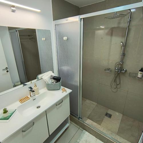 a bathroom with a shower and a sink and a mirror at Condo Blaxy Resort Olimp in Olimp