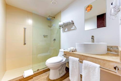 a bathroom with a toilet and a sink and a shower at Sleep Inn Mazatlan in Mazatlán