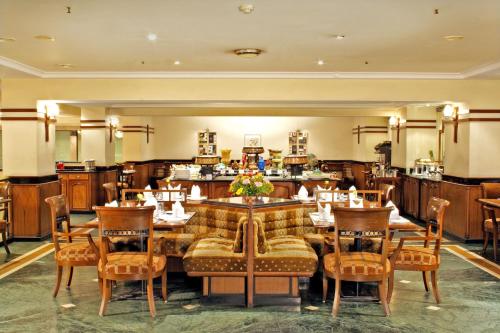 a restaurant with a large wooden table and chairs at Aditya Park-A Sarovar Portico Hotel in Hyderabad