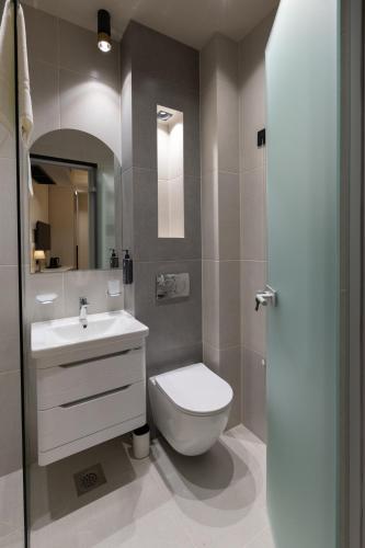 a bathroom with a white toilet and a sink at Boutique Hill Hotel in Požarevac
