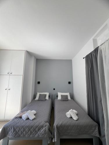 a bedroom with two beds with towels on them at Elena Studios in Panormos