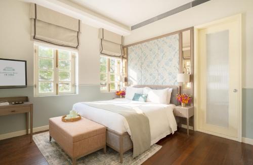 a bedroom with a large white bed and windows at Tai O Heritage Hotel in Hong Kong