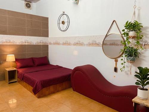 a bedroom with a red bed and a mirror at Nhà Nghỉ Đạt Thành in Giồng Tú Ðiền