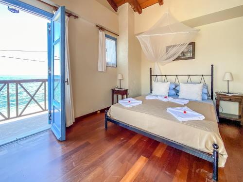 a bedroom with a bed and a large window at Kyparissis Beach house 1 in Lésvos