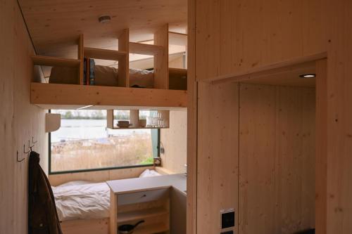 a room with a bunk bed and a desk and a window at Tiny House Nook 3 - Green&Tiny Hideaway Eider in Süderstapel