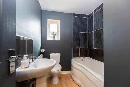 a bathroom with a sink and a tub and a toilet at Spacious 3BR Durham Home Contractor Friendly in Durham