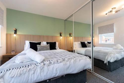a bedroom with two beds and a large mirror at Spacious 3BR Durham Home Contractor Friendly in Durham