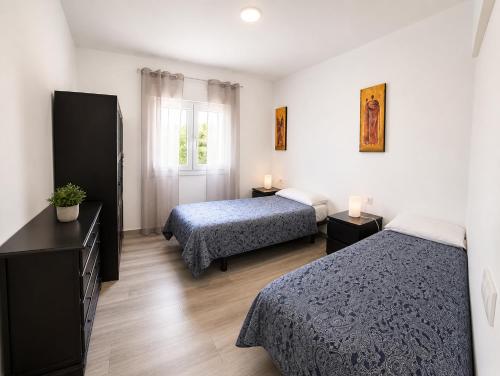 a hotel room with two beds and a window at Parisito Sancti Petri - Villa amplia con piscina privada in Chiclana de la Frontera