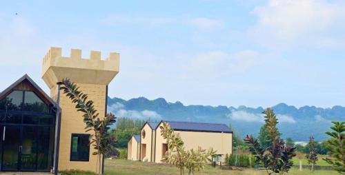 a building with a tower on the side of it at Kiangnapa Cottage in Kanchanaburi City