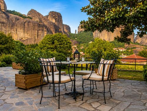 a table and chairs with a view of the mountains at Hotel Doupiani House in Kalabaka