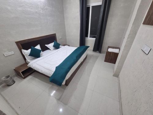 a bedroom with a bed with blue pillows at Deep Heritage Hotel & Restaurant in Phata