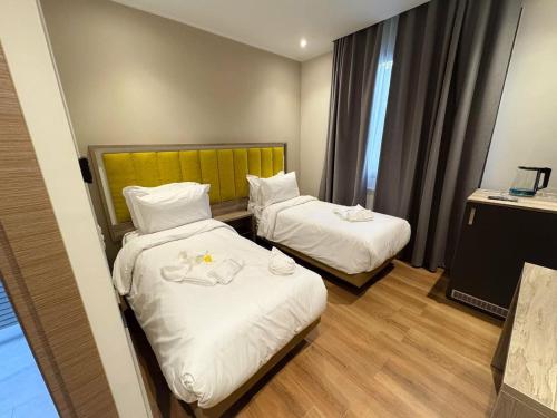 a hotel room with two beds with white sheets at Hôtel Corner King in Skikda