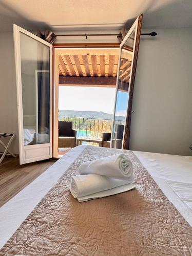 a bedroom with a bed with a view of the ocean at Auberge des Salles in Les Salles-sur-Verdon