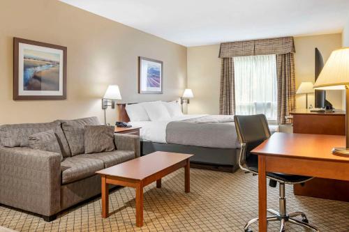 a hotel room with a bed and a couch at Quality Inn Airport in Moncton
