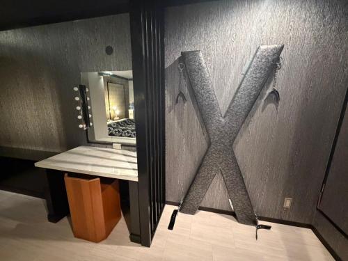 a bathroom with a mirror with the letter x on the wall at ホテル 天使と悪魔 in Gobō